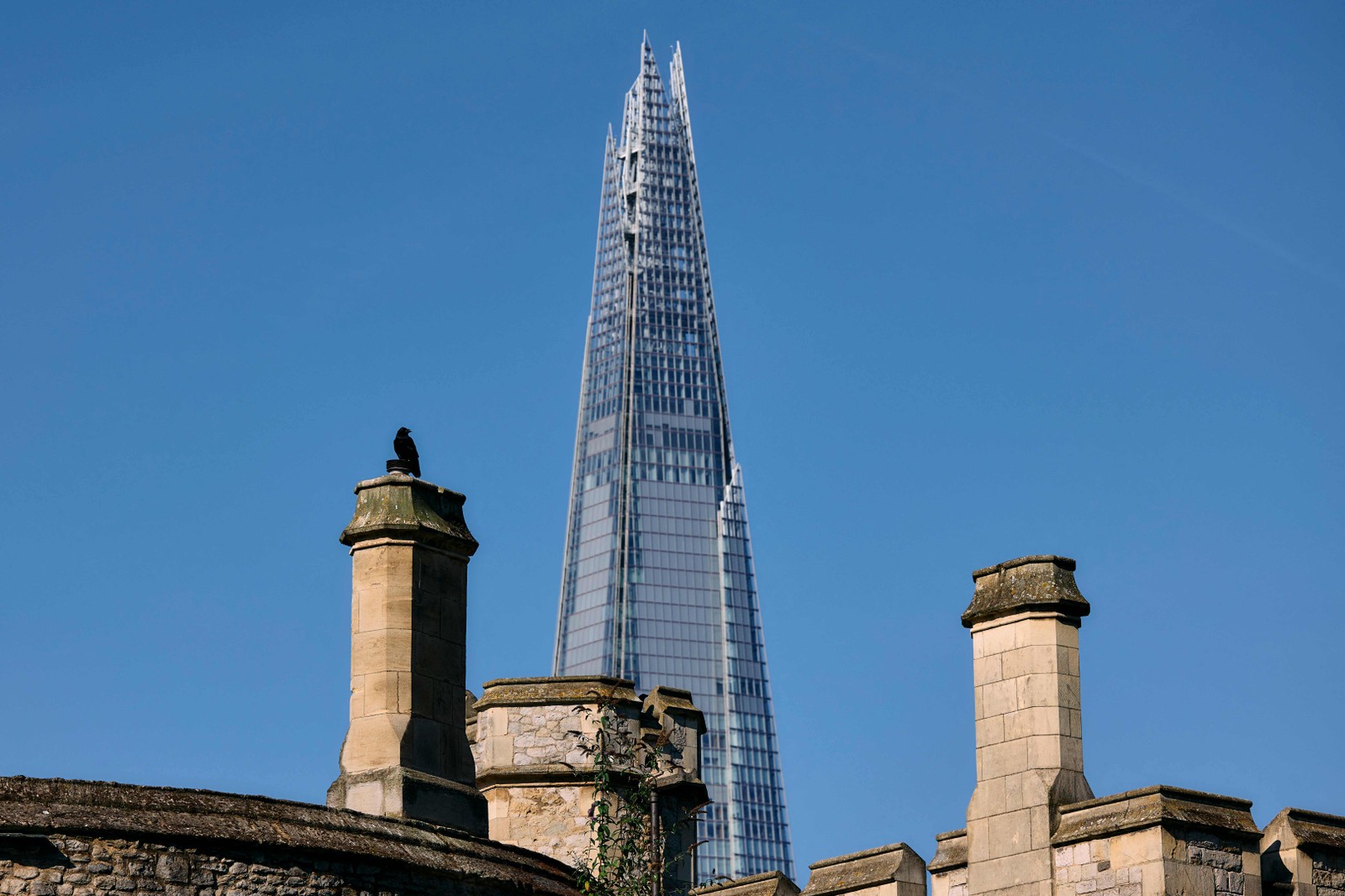 O contraste entre as chaminés da Torre de Londres e o arranha-céu The Shard, que tem 309 metros de altura e é o mais alto edifício do Reino Unido — Foto: Benjamin Cremel / AFP