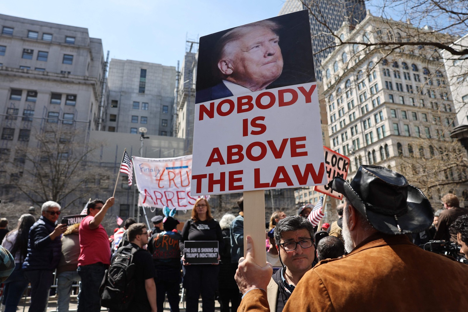 Críticos protestam contra o ex-presidente Donald Trump do lado de fora do Tribunal Criminal de Manhattan antes de sua acusação — Foto: SPENCER PLATT / Getty Images via AFP