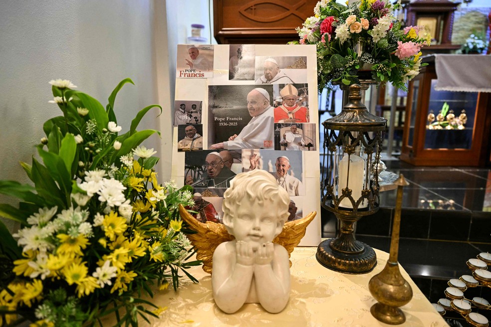 Retratos do Papa Francisco são exibidos antes de uma missa em homenagem à sua morte na Igreja do Sagrado Coração em Bentong, na tailândia, em 21 de abril de 2025 — Foto: MOHD RASFAN / AFP