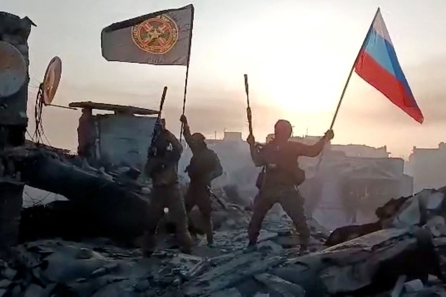 Soldados ligados ao Wagner mostram bandeiras russa e do grupo em Bakhmut