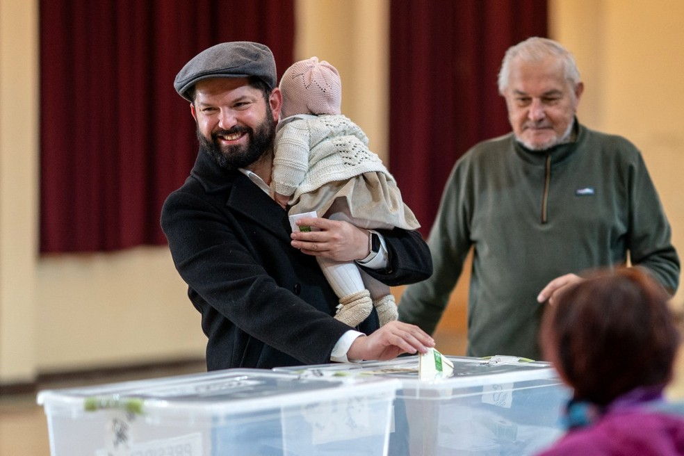 O presidente chileno Gabriel Boric com sua filha Violeta votando nas eleições gerais em Punta Arenas, província de Magalhães, Chile, em 16 de novembro de 2025 — Foto: MARCELO SEGURA / AFP