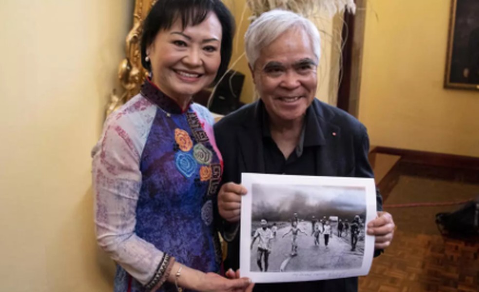 Kim Phuc Phan Thi posa com Nick Ut, que segura a foto 'Garota Napalm', em 2023 — Foto: Ezequiel BECERRA / AFP