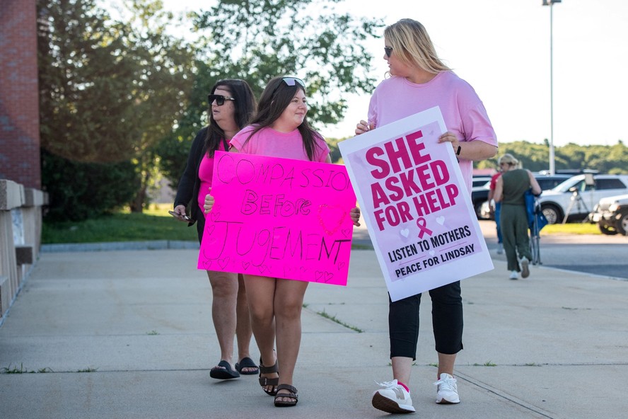 Apoiadores de Lindsay Clancy seguram cartazes do lado de fora do Tribunal Superior do Condado de Plymouth durante o julgamento por homicídio de Lindsay Clancy, em Plymouth, Massachusetts, em 26 de agosto de 2026. Lindsay Clancy está sendo julgada pela morte por estrangulamento de seus três filhos pequenos, ocorrida em janeiro de 2023.