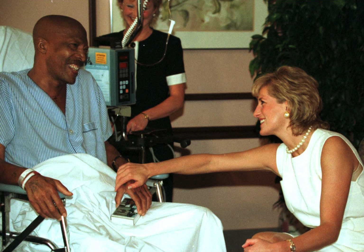 Diana, em 1996, se encontra com John Collins, paciente com câncer de pulmão, enquanto visitava a Unidade de Cuidados Paliativos do Northwestern Memorial Hospital, em Chicago — Foto: Sue OGROCKI / AFP