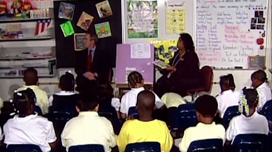 O então presidente dos EUA George W. Bush sentado em uma sala de aula na em Sarasota, Flórida, no momento em que é informado sobre os ataques de 11 de setembro de 2001