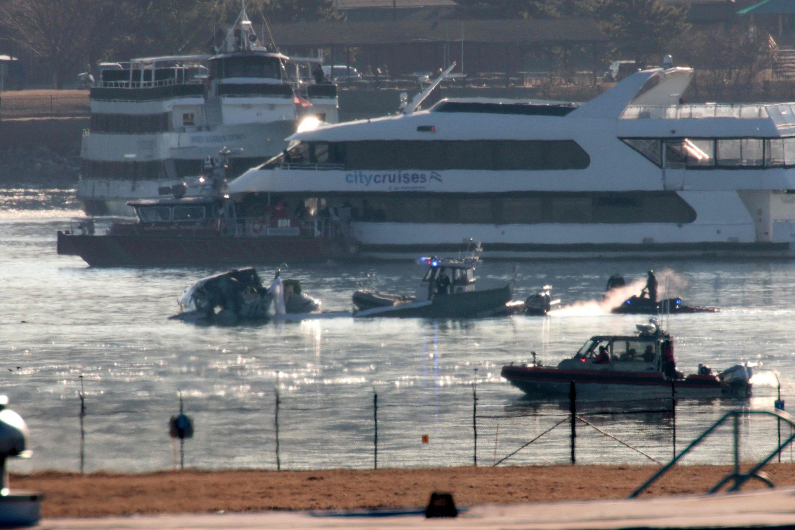 Unidades de resposta a emergências revistam os destroços de um avião da American Airlines no Rio Potomac — Foto: ALEX WONG / GETTY IMAGES NORTH AMERICA / Getty Images via AFP