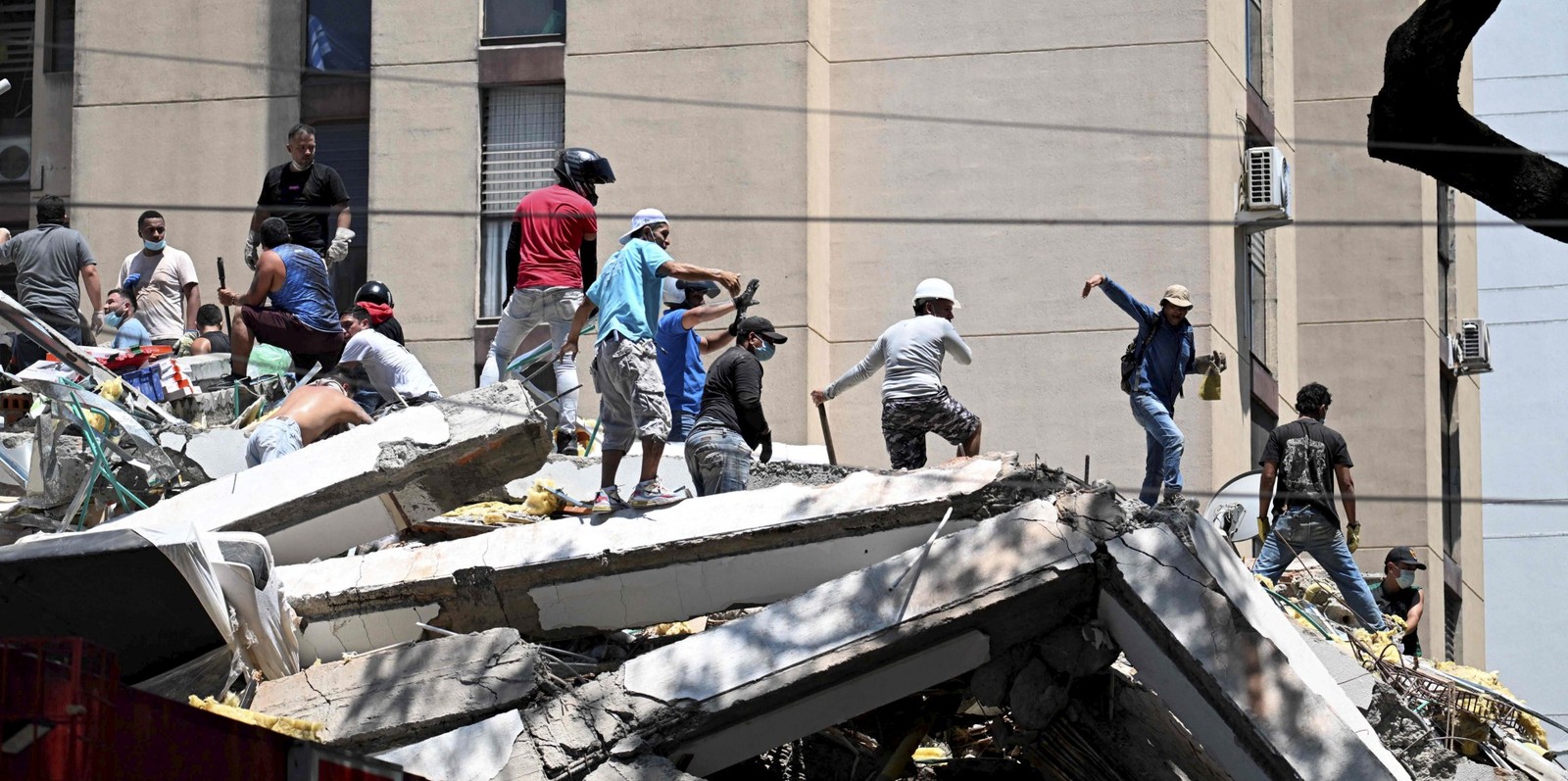 Equipes de resgate procuram por sobreviventes entre os escombros de um prédio que desabou após um terremoto em Cali, Colômbia, — Foto: Joaquin Sarmiento / AFP