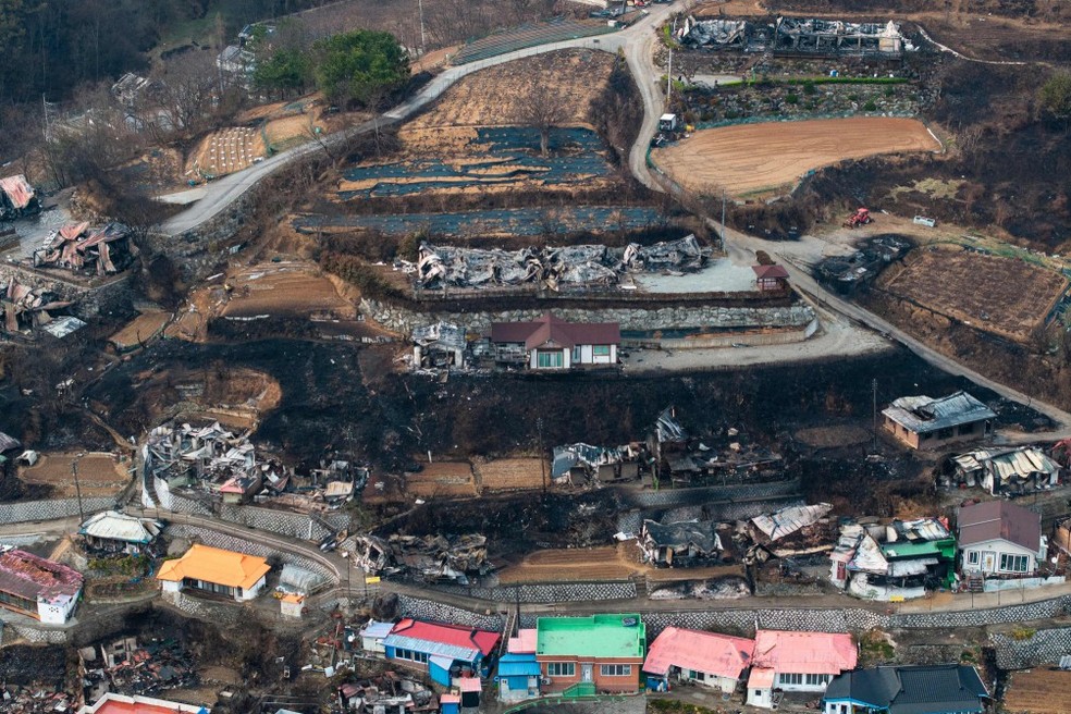 Uma vista aérea mostra propriedades devastadas por incêndios florestais na vila costeira de Nomul-ri, em Yeongdeo, na Coreia do Sul — Foto: Anthony Wallace / AFP