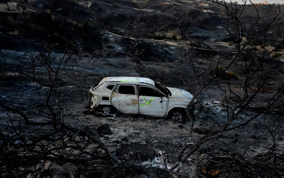 Carro destru&iacute;do por inc&ecirc;ndio florestal nos arredores de B&egrave;dar, no sul da Espanha &mdash; Foto: JOSE JORDAN / AFP