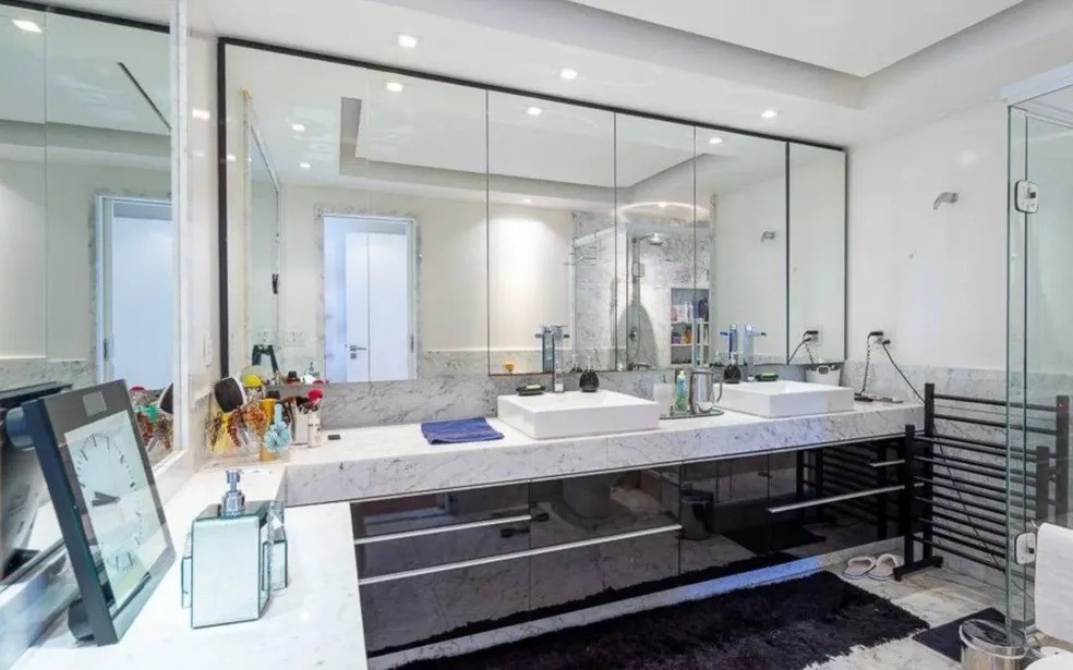 Banheiro da suíte principal é equipado com pia dupla e duas duchas — Foto: Reprodução
