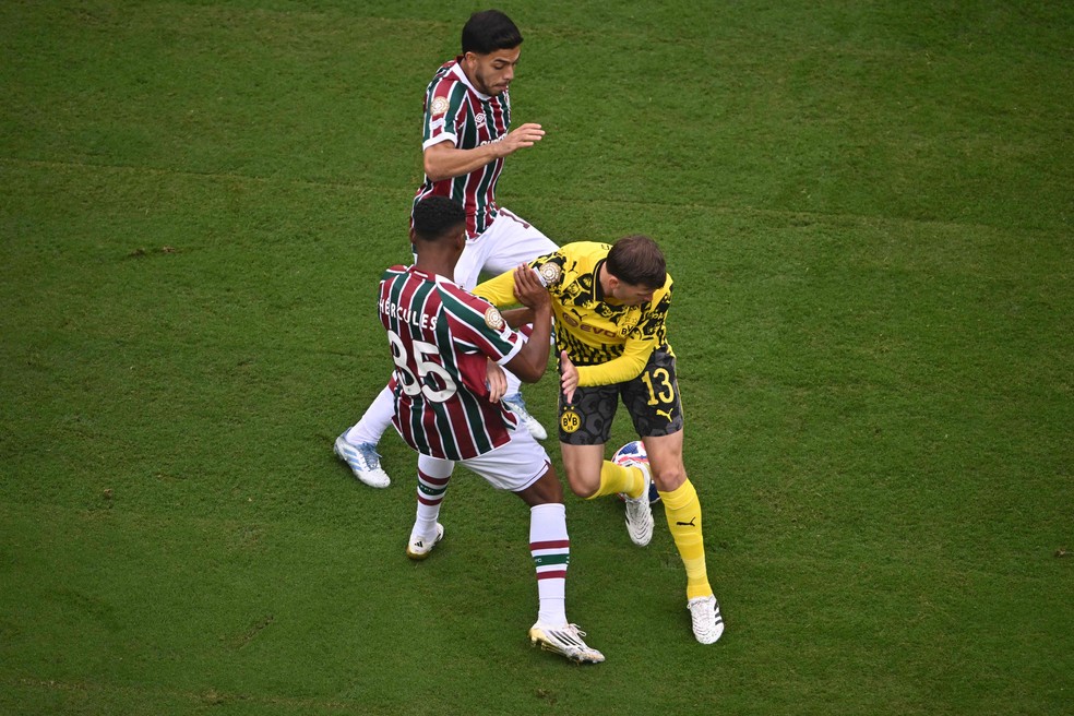 Pascal Gross, do Dortmund, disputa a bola com Hercules e Nonato do Fluminense — Foto: ANGELA WEISS / AFP