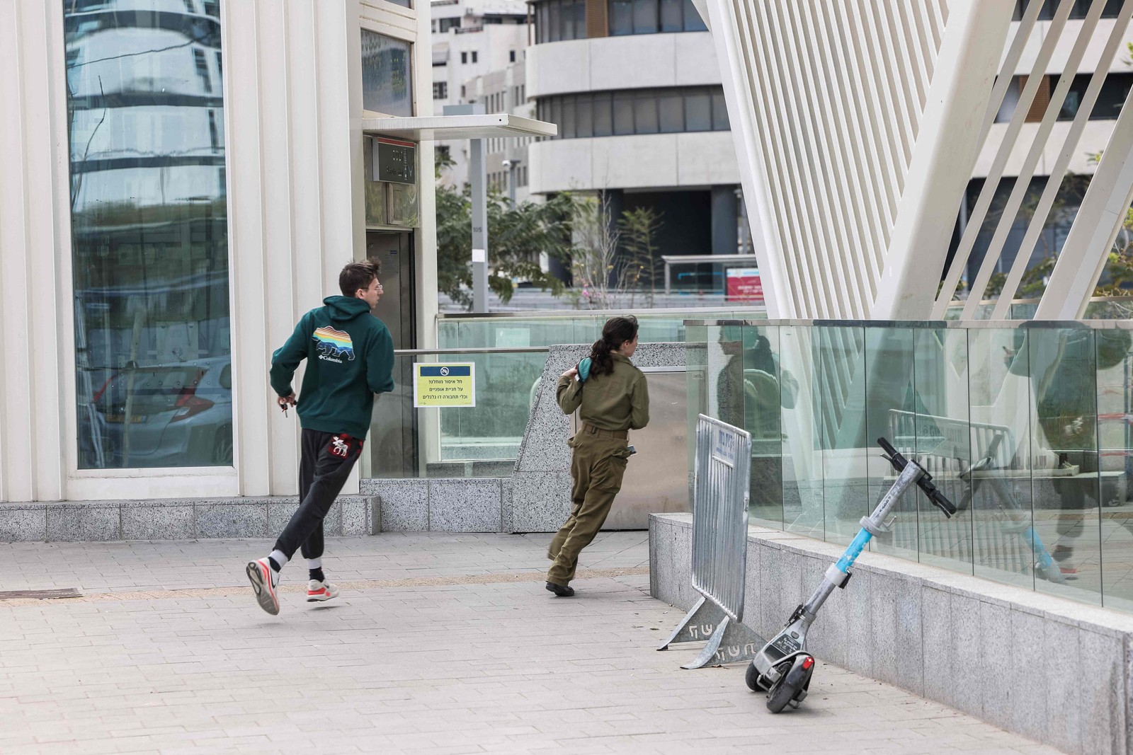 People rush to shelter as sirens sound in Tel Aviv. The Israel Defense Forces said its attacks against Iran, in coordination with the United States, hit dozens of military installations. — Photo: Jack GUEZ / AFP