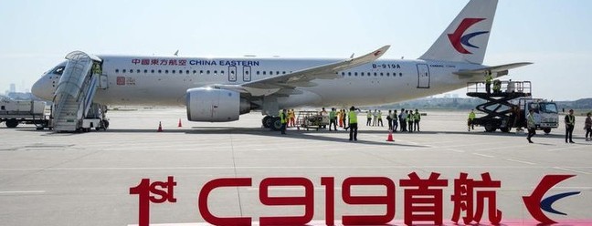 O primeiro jato de passageiros produzido na China, o C919, aparece estacionado na pista do aeroporto de Xangai antes de seu voo inaugural para Pequim-AFP