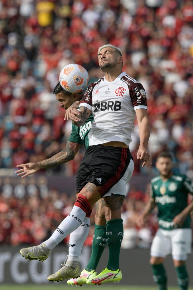 O jogador alviverde Dudu e Arrascaeta, do Flamengo, sobem pra cabecearAFP
