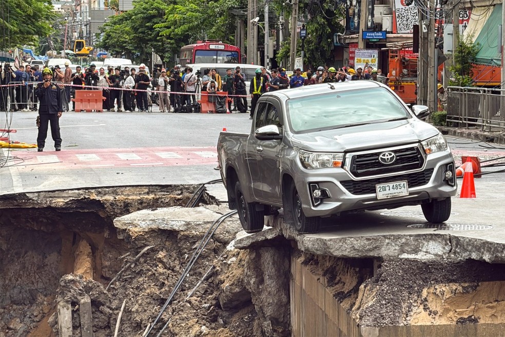 Cratera gigante engole rua em Bangcoc após colapso em obra de metrô — Foto: AFP