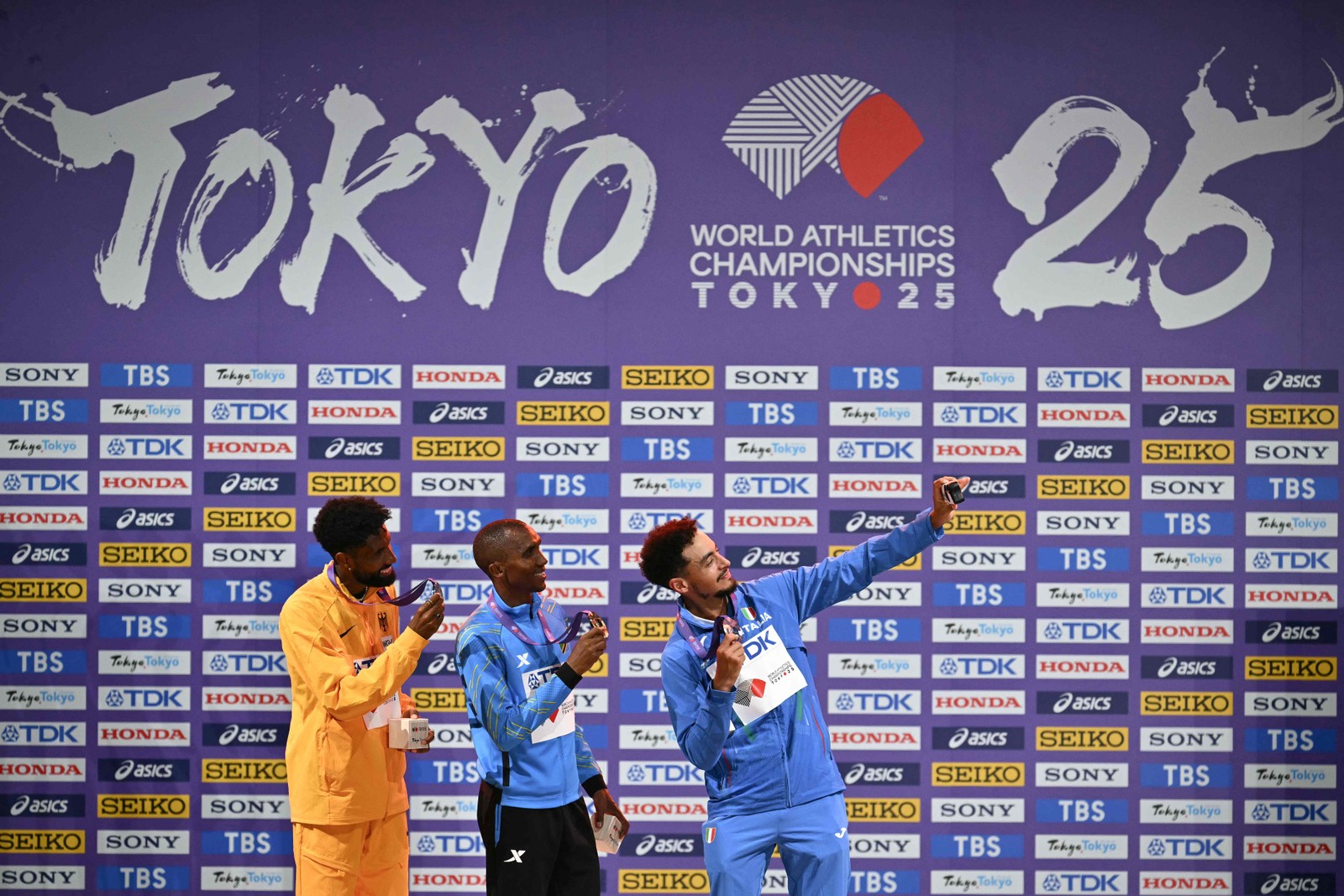Pódio com Amanal Petros (prata), Alphonce Felix Simbu (ouro) e Iliass Aouani (bronze)