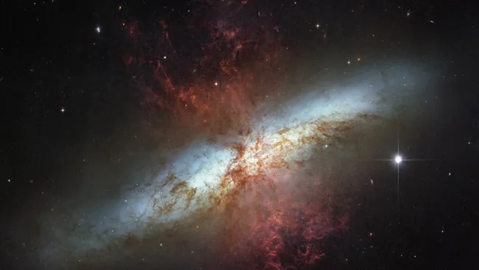 Observações do Telescópio Hubble da gloriosa galáxia M82, repleta de luz estelar branca e nuvens de gás vermelhas. As estrelas estão se formando 10 vezes mais rápido aqui do que na Via Láctea, de acordo com a NASA. — Foto: NASA, ESA e Hubble Heritage Team (STScI/AURA)