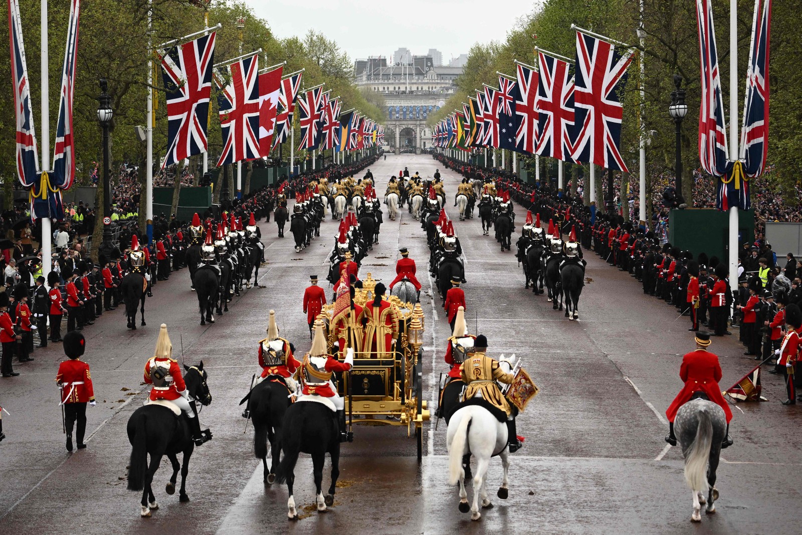 Carruagem do rei Charles deixa o Palácio de Buckingham em direção à Abadia de Westminster para a coroação — Foto: Marco BERTORELLO / AFP