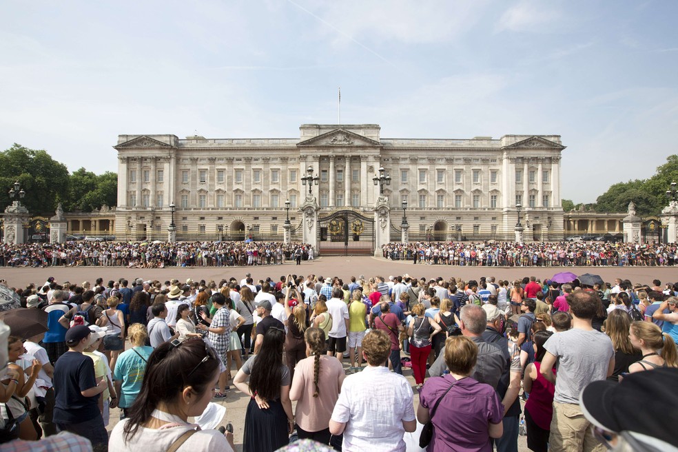 Sede da monarquia britânica em Londres, o Palácio de Buckingham vive cercado por visitantes do mundo inteiro — Foto: AFP