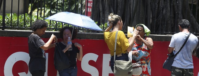 No ENEM, candidatos esperaram com guarda-chuvas para se proteger do Sol — Foto: Fabiano Rocha/Agência O Globo