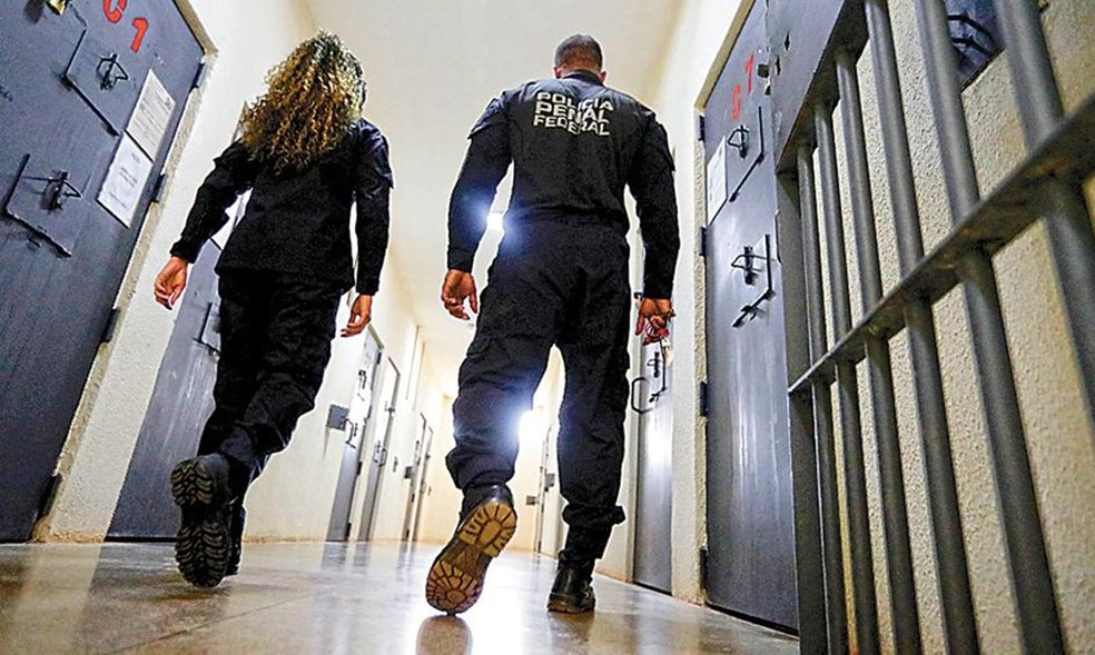 Agentes da penitenciária de Brasília andam numa das alas com corredores limpos: o silêncio absoluto é regra; luzes são acesas às 7h e apagadas às 22h — Foto: Agência O Globo/Cristiano Mariz
