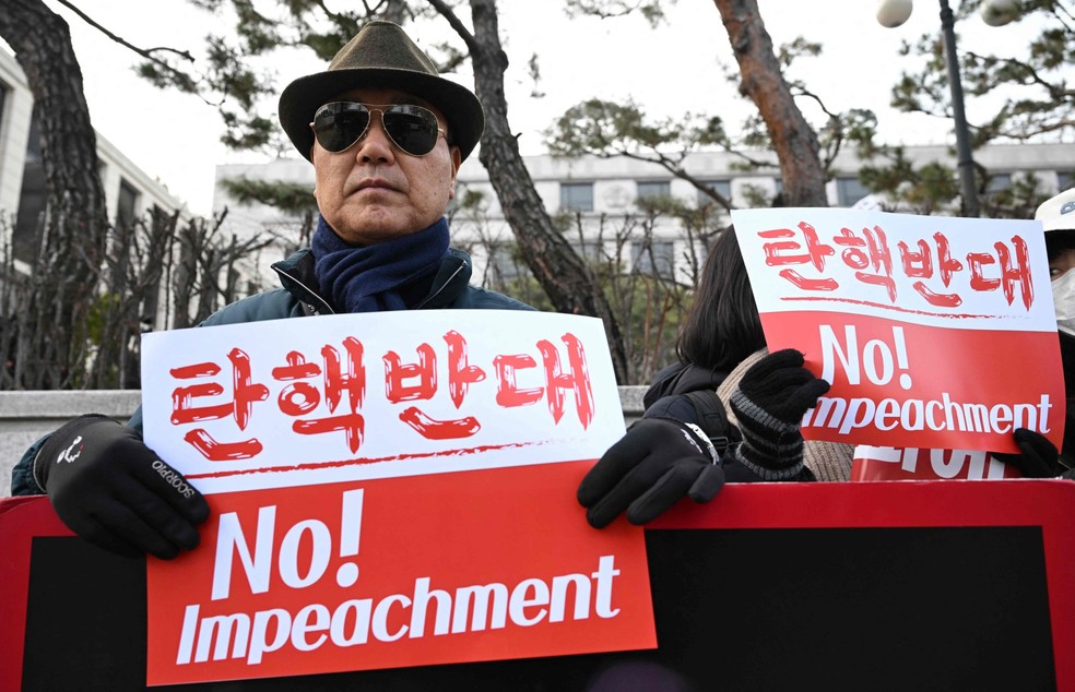 Apoiadores de Yoon se manifestam em frente à sua casa durante operação para prendê-lo pedindo para que impeachment não seja chancelado pela Suprema Corte — Foto: AFP