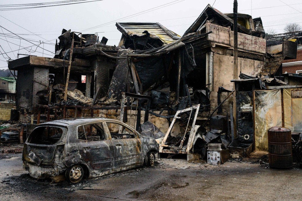 Propriedades foram devastadas por incêndios florestais na vila costeira de Nomul-ri, em Yeongdeo, na Coreia do Sul — Foto: Anthony Wallace / AFP