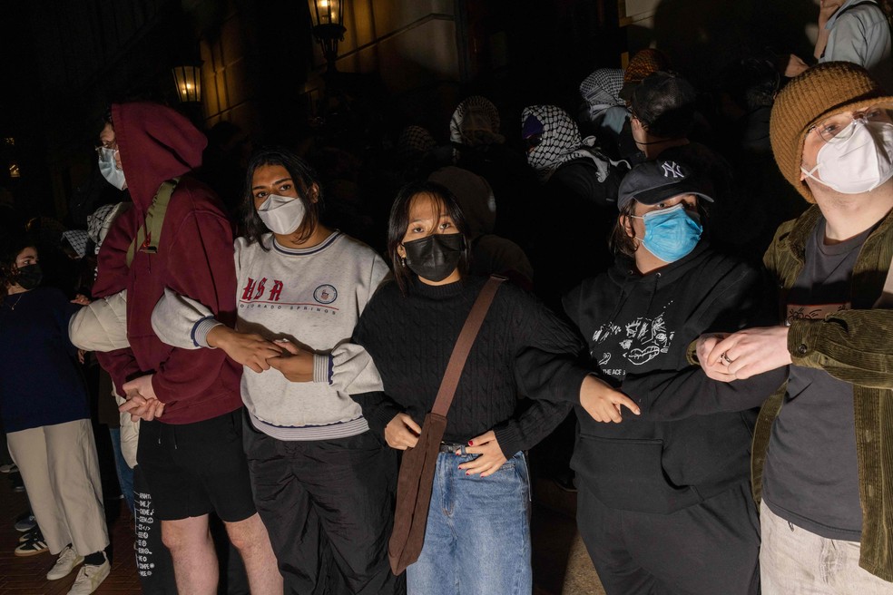 Estudantes fazem barreira humana para impedir que autoridades chegue a colegas entrincheirados em prédio da universidade — Foto: Alex Kent/Getty Images North America via AFP