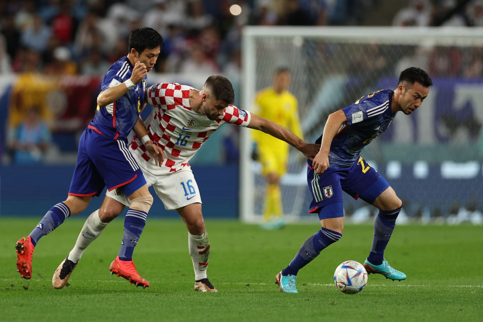 Atacante croata Bruno Petkovic se agarra nos japoneses na disputa pela bola — Foto: ADRIANO DENNIS/AFP