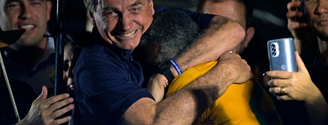 Flopou. Jair Bolsonaro abraça um dos poucos apoiadores após participar de um comício como parte de sua campanha à reeleição, na Praça da Liberdade, em Belo Horizonte, Minas Gerais  — Foto: DOUGLAS MAGNO / AFP