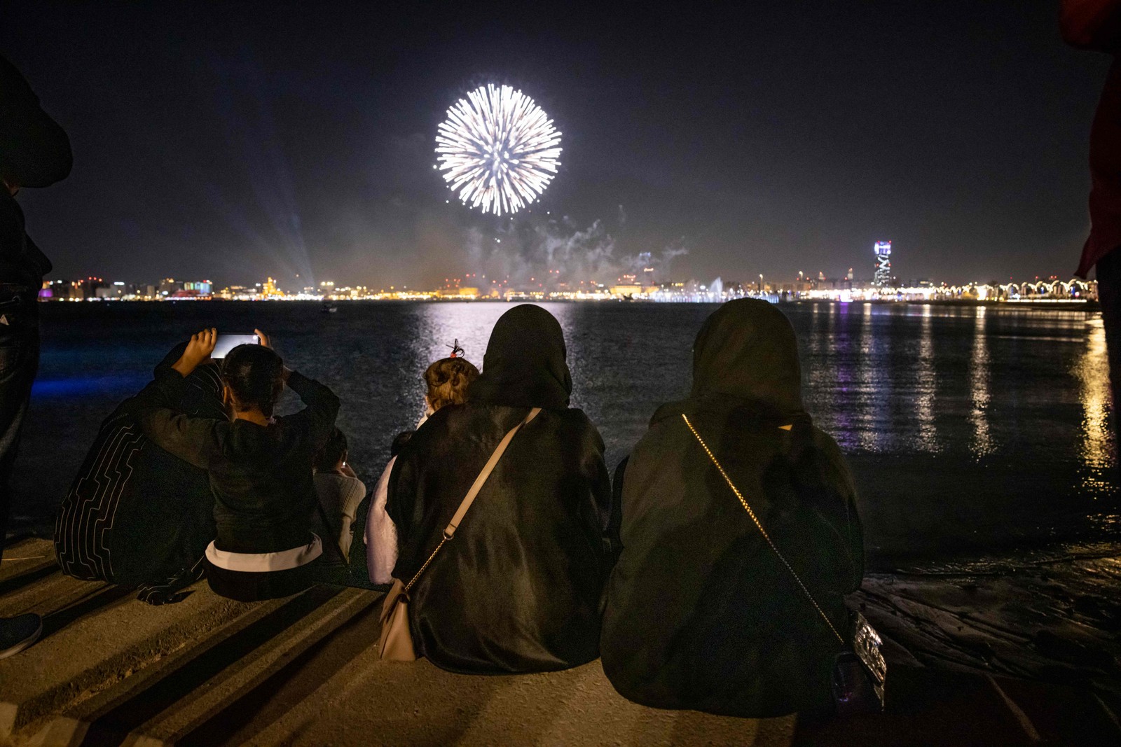 Mulheres olham para fogos de artifício explodindo no céu em Doha abertura do torneio de futebol da Copa do Mundo Qatar — Foto: FADEL SENNA/AFP
