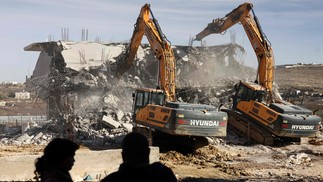 Escavadeiras israelenses demolem uma casa palestina em construção sem permissão das autoridades israelenses, na cidade ocupada de Hebron, na Cisjordânia — Foto: HAZEM BADER / AFP