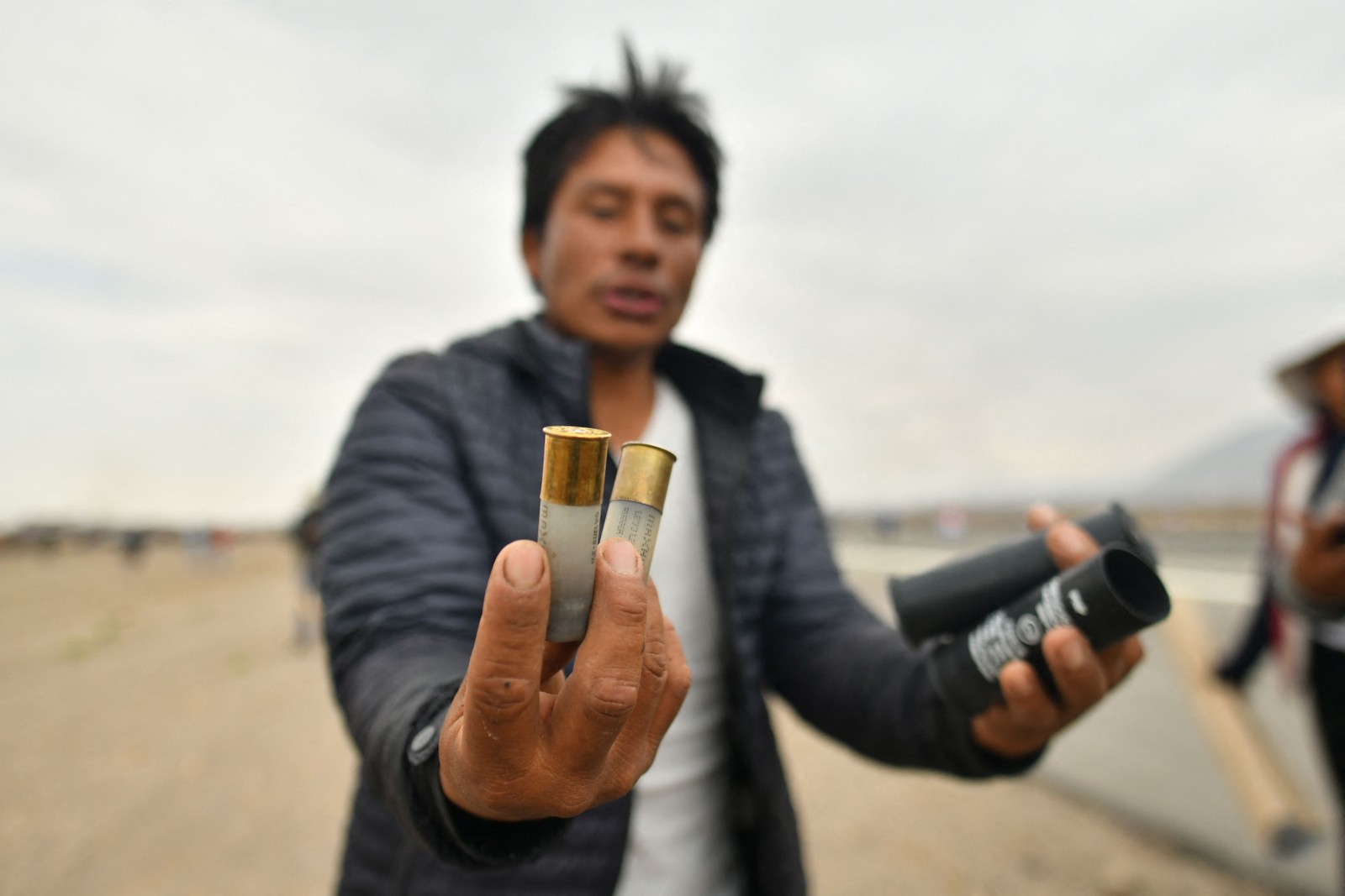 Manifestante mostra bombas de gás lacrimogêneo enquanto toma o aeroporto internacional Alfredo Rodríguez Ballon — Foto: Diego Ramos / AFP