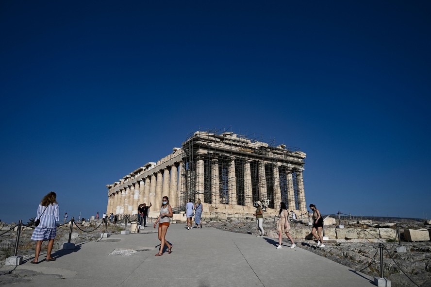 Turistas em frente às ruínas do Partenon, na Acrópole de Atenas, Grécia