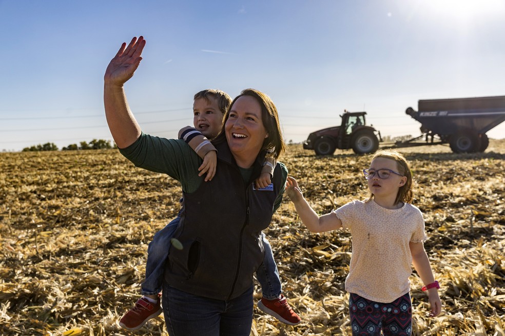 Summer Ory, com seus dois filhos, na fazenda de Earlham, no Iowa: um reduto trumpista que sofre economicamente — Foto: Kathryn Gamble/NYT