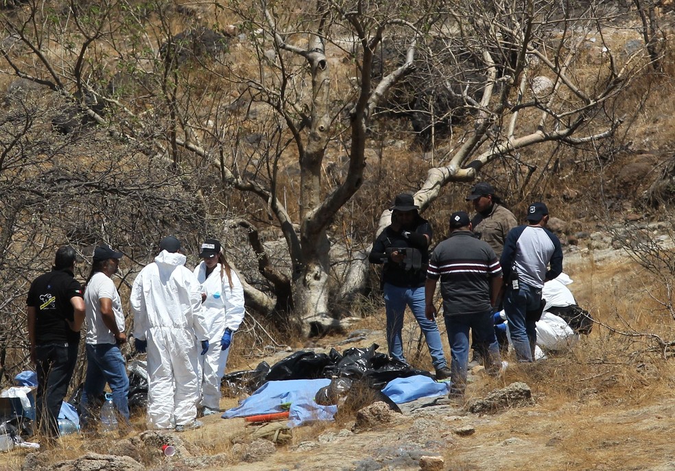 Número de vítimas que teriam resultado nesses restos mortais ainda é desconhecido, mas já foi possível identificar que havia homens e mulheres — Foto: Ulises Ruiz / AFP