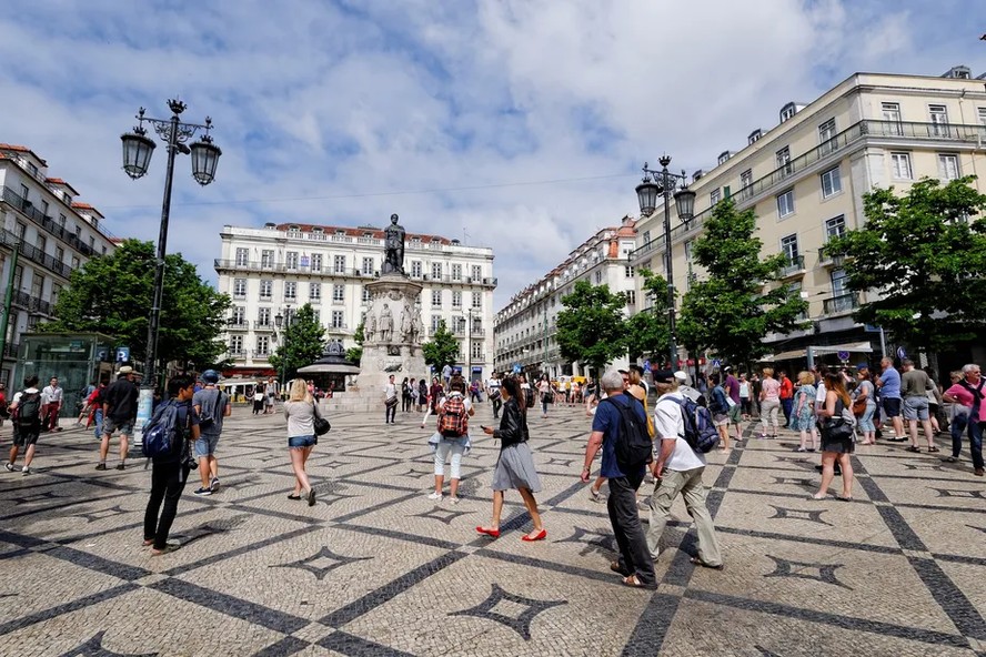 Pedestres caminham na Praça de Luís de Camões, em Lisboa