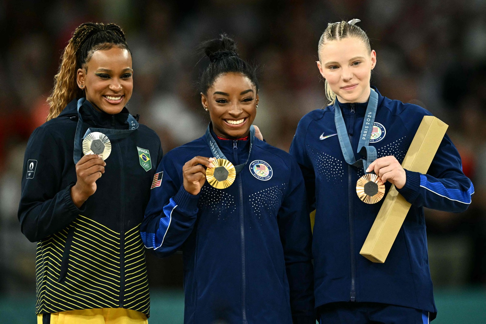 Rebeca Andrade (prata), Simone Biles (ouro) e Jade Carey (bronze) no pódio do salto da ginástica artística em Paris — Foto: Lionel BONAVENTURE / AFP