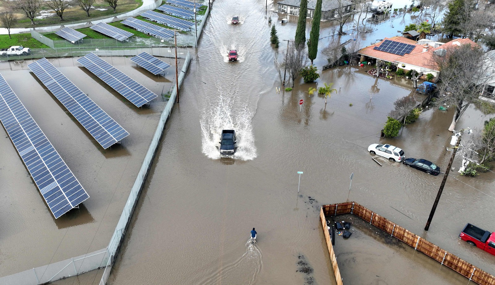 Carros trafegam por uma estrada inundada em Planada, Califórnia — Foto: JOSH EDELSON / AFP