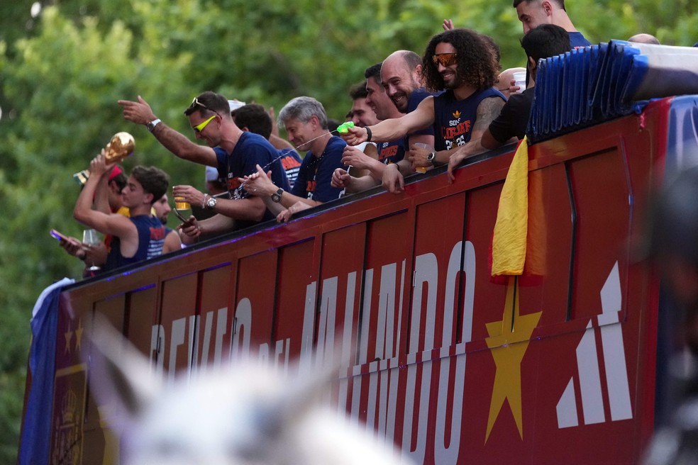 O defensor Marc Cucurella dispara uma pistola de água enquanto os jogadores da Espanha desfilam em um ônibus aberto pelas ruas de Madri, em 20 de julho de 2026, um dia após a seleção conquistar seu segundo título da Copa do Mundo com a vitória por 1 a 0 sobre a Argentina.  Os campeões mundiais retornaram à capital espanhola para uma recepção de heróis, onde cerca de um milhão de torcedores eram esperados para saudá-los após uma noite de intensas comemorações por todo o país — Foto: Cesar MANSO / AFP