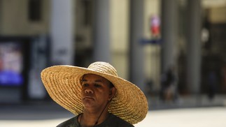 Vendedor ambulante recorre a chapéu para se proteger do sol no Centro do Rio — Foto: Gabriel de Paiva