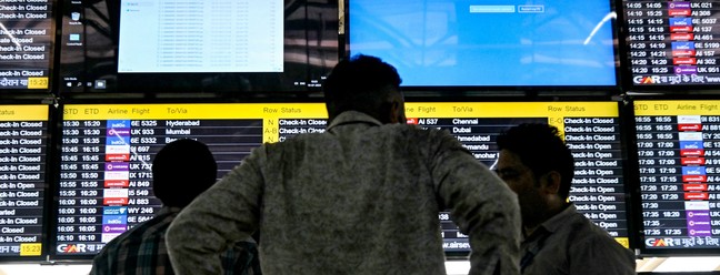 Telas mostram mensagens de erro em meio a uma interrupção global no Aeroporto Internacional Indira Gandhi, em Nova Delhi — Foto: AFP