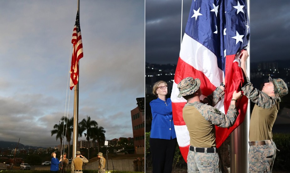 Bandeira dos Estados Unidos sendo hasteada na embaixada de Caracas sob céu limpo. Bandeira americana hasteada na embaixada de Caracas simbolizando retorno diplomático dos Estados U