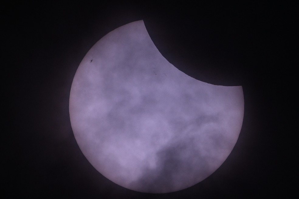 A lua passa na frente do sol durante um eclipse solar parcial, visto de Berlim, Alemanha — Foto: AFP