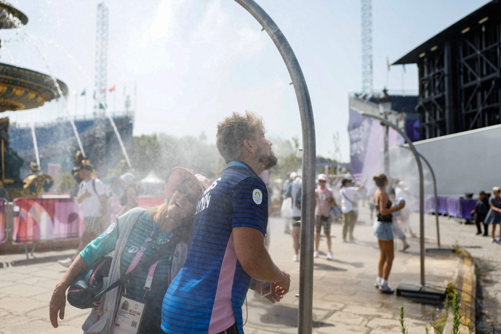 The public cools off from high temperatures in the showers — Photo: Odd ANDERSEN / AFP