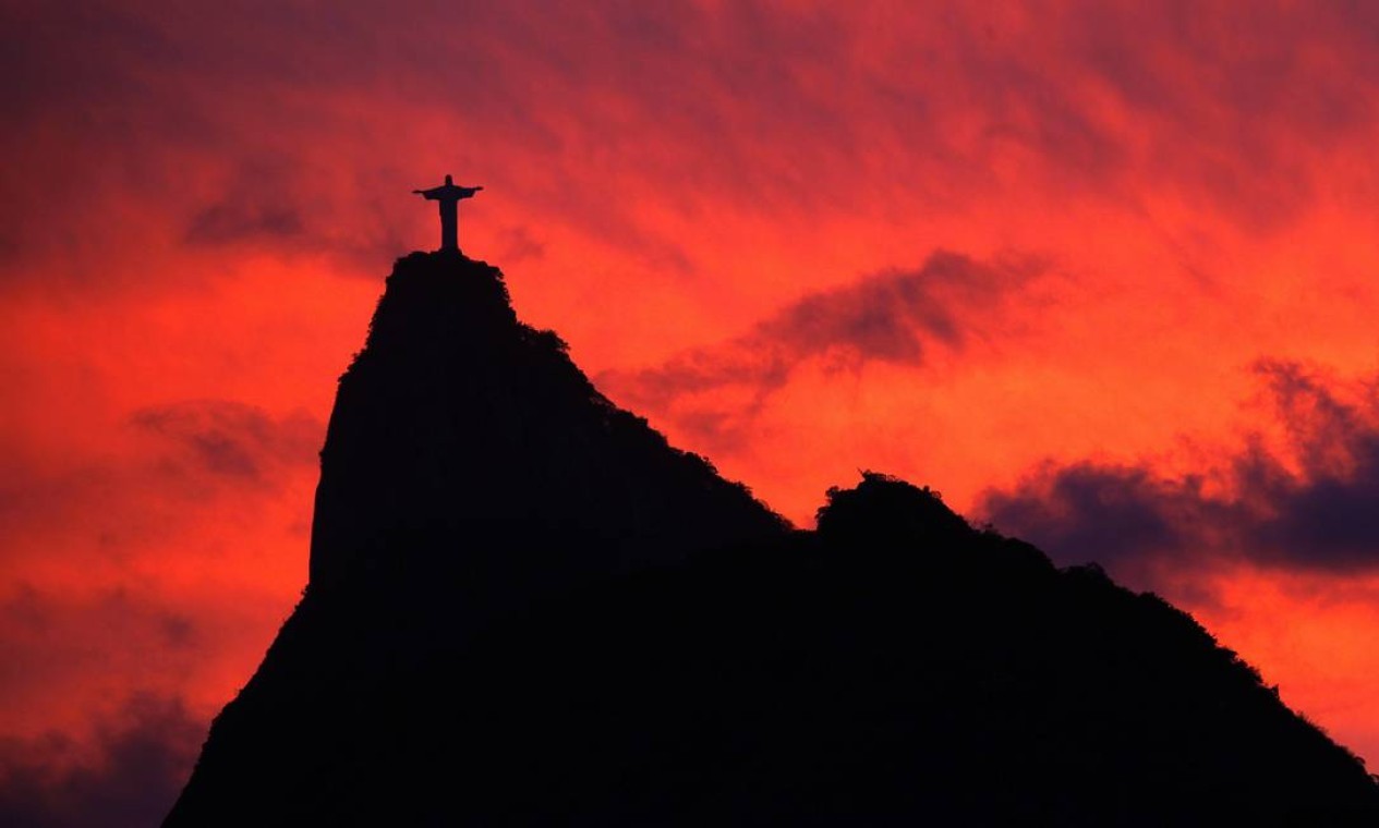 Silhueta do Corcovado, com o Cristo Redentor no topo. é vista em contraste com céu avermelhado de um pôr do sol em 2009  — Foto: Custódio Coimbra / Agência O Globo