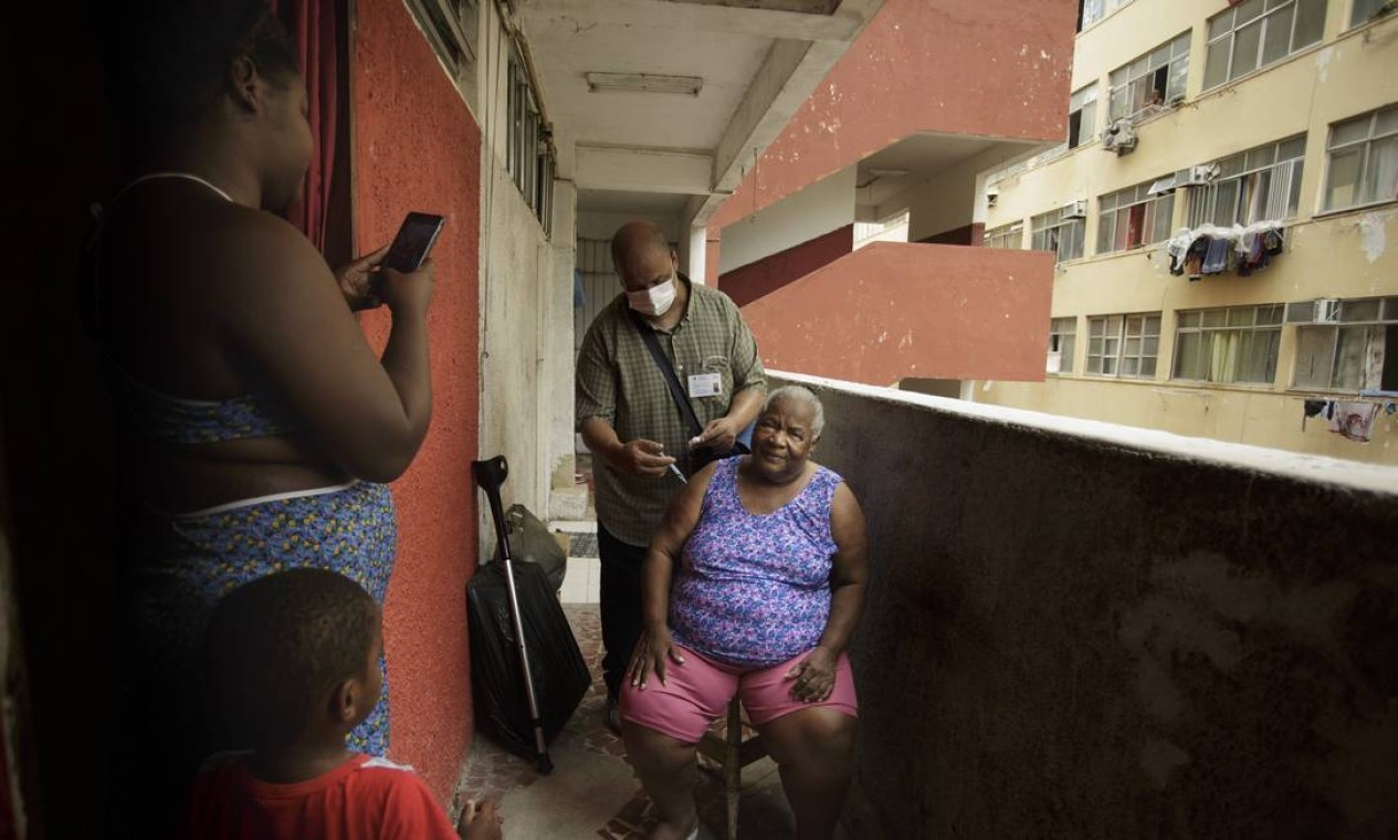 Dijanira Chagas da Silva, de 86 anos, é imunizada contra a Covid-19 em sua casa, na Cruzada São Sebastião, no Leblon. Equipe Trombeta, da Secretaria Municipal de Saúde, faz a vacinação em casa de idosos com dificuldades de locomoção — Foto: Márcia Foletto / Agência O Globo