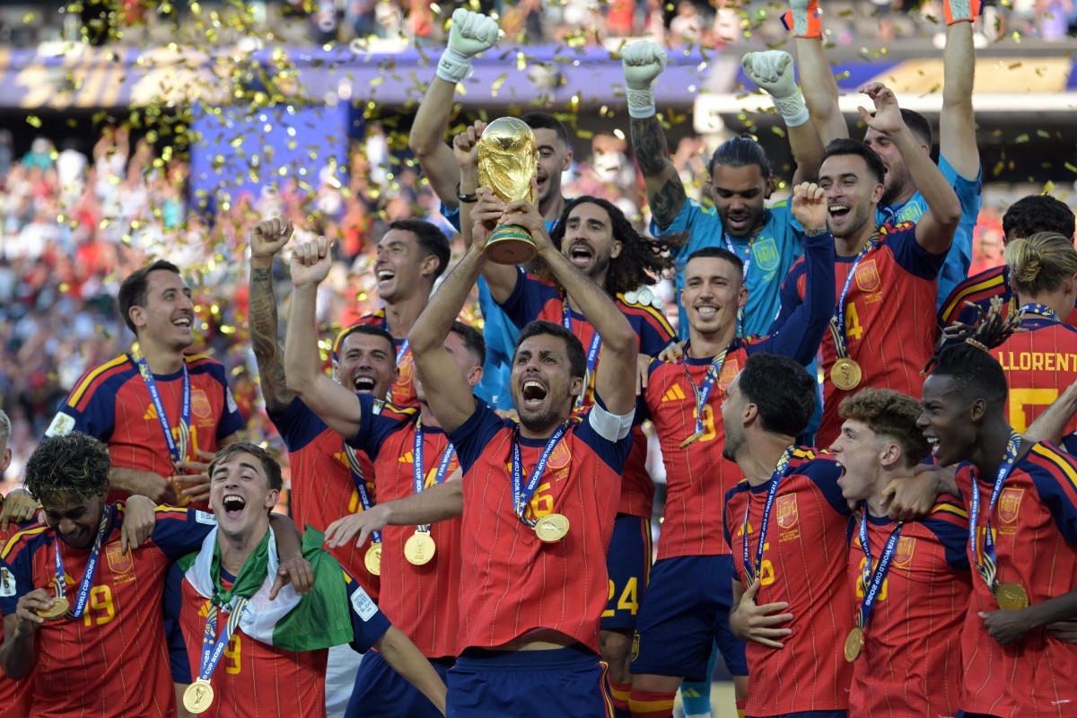 O meio-campista espanhol número 16, Rodri, ergue o troféu com seus companheiros de equipe após a vitória na final da Copa do Mundo de 2026 entre Espanha e Argentina — Foto: JUAN MABROMATA / AFP