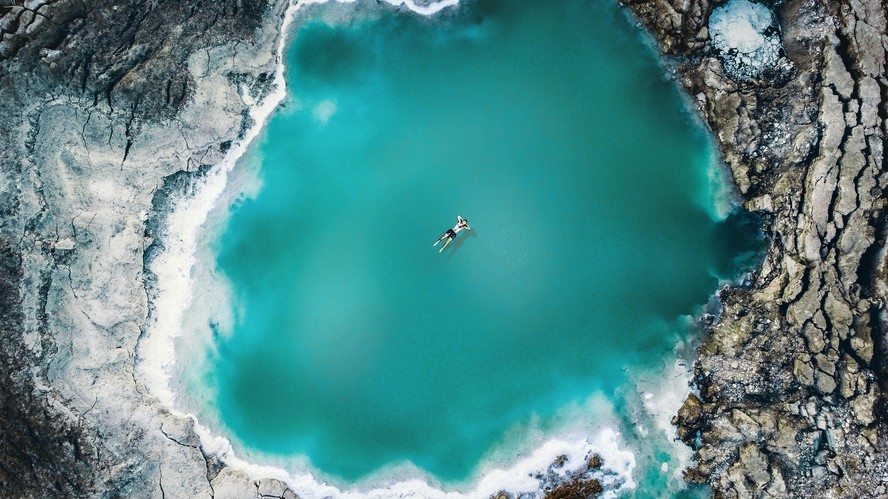 MAR MORTO (Israel/Palestina/Jordânia): Situado a mais de 300 metros abaixo do nível do mar, é o lago salgado mais baixo do mundo. Com salinidade dez vezes maior que a dos oceanos, impede a vida aquática, mas permite flutuar sem esforço. Seus minerais atraem visitantes em busca de benefícios terapêuticos, tornando-o destino turístico e espiritual.