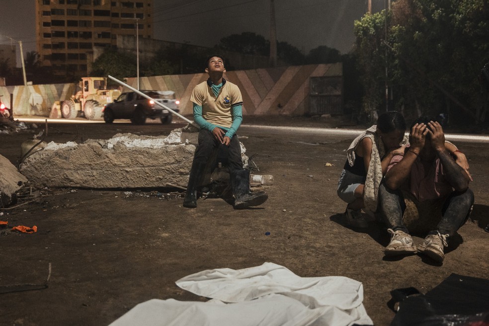 Deivi Delf&iacute;n apoia-se em escombros para lamentar a perda de familiares, cujos corpos foram recuperados ap&oacute;s terremotos consecutivos em Caraballeda, Venezuela, em 19 de julho de 2026 &mdash; Foto: Adriana Loureiro Fernandez / The New York Times